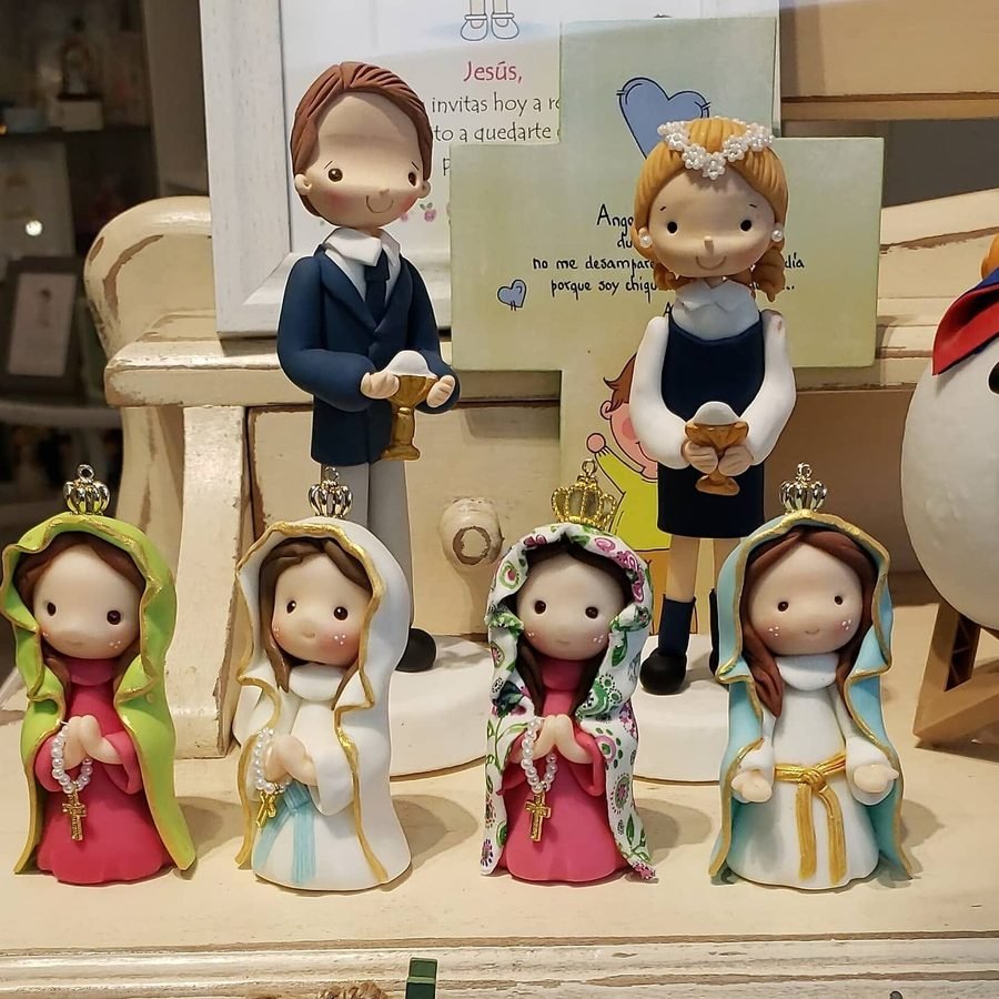 Figuras de niño y niña de Primera Comunión junto a virgencitas de cerámica